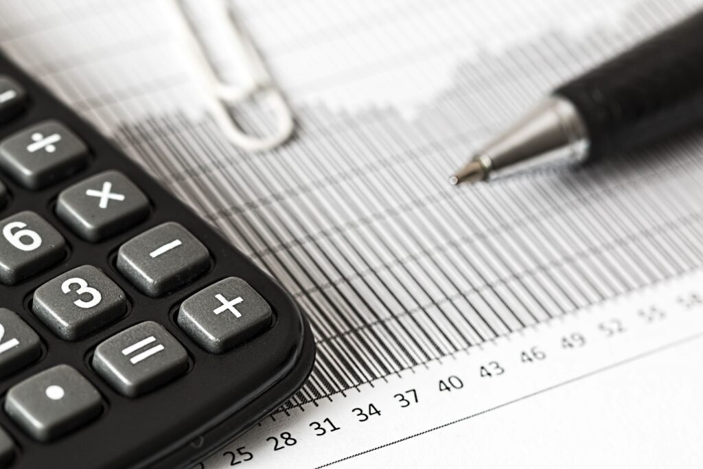 Kalkulator i długopis na wydruku wykresu finansowego