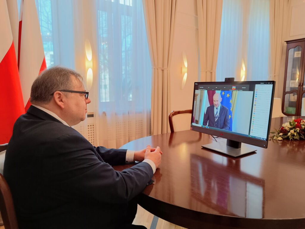 Jarosław Wyrembak przed ekranem z transmisją uroczystości łotewskiego sądu