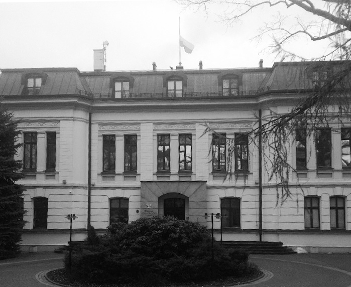 Czarno-białe zdjęcie siedziby Trybunału Konstytucyjnego z flagą opuszczoną na maszcie