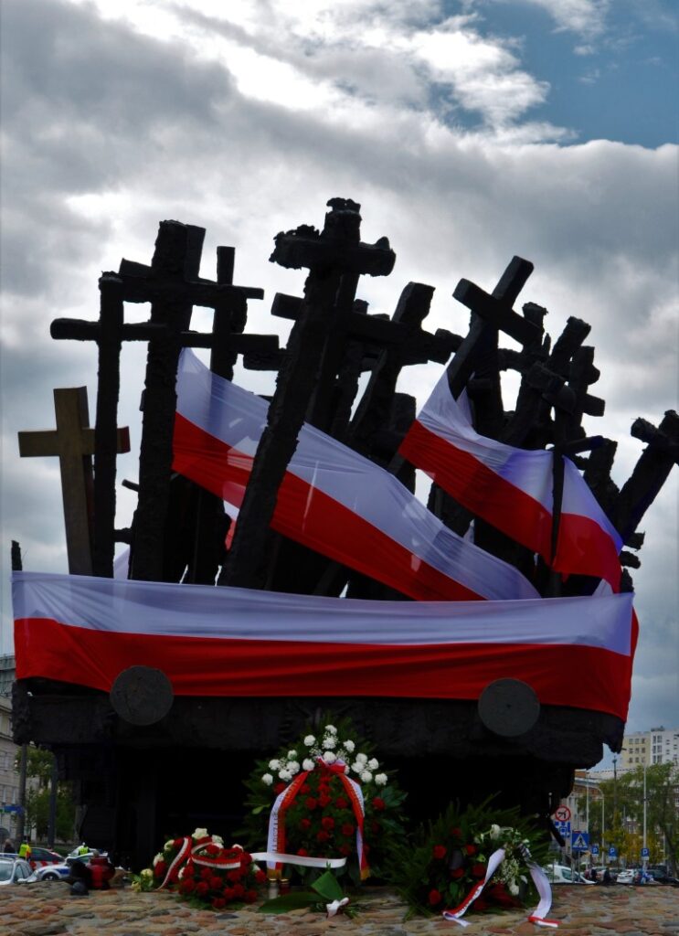Krzyże, polskie flagi i wieńce przy Pomniku Poległym i Pomordowanym na Wschodzie