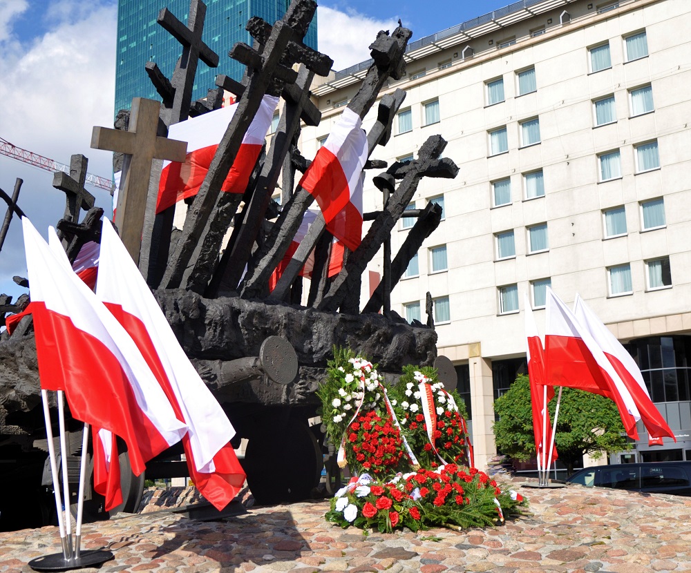Krzyże, biało-czerwone flagi i wieńce przy Pomniku Poległym i Pomordowanym na Wschodzie