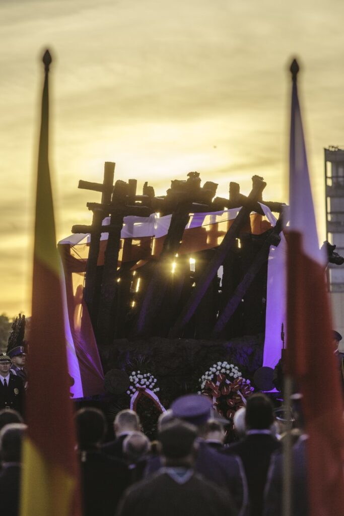 Pomnik Poległym i Pomordowanym na Wschodzie otoczony uczestnikami uroczystości i flagami
