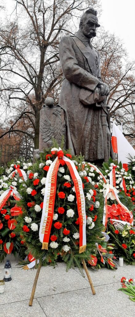 Pomnik Józefa Piłsudskiego oraz biało-czerwone wieńce u jego stóp