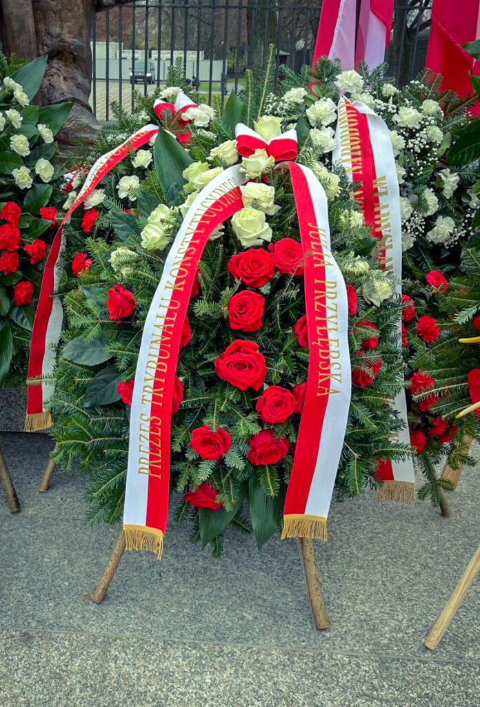 Wieniec z czerwonych i białych róż oraz biało-czerwona szarfa z nazwiskiem prezes TK Julii Przyłębskiej
