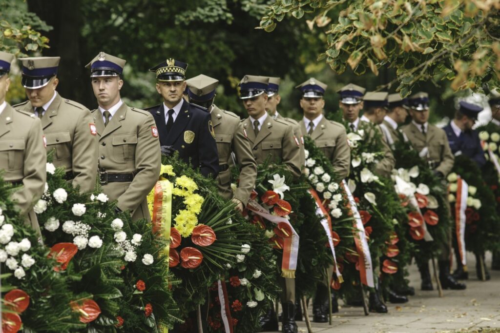Żołnierze i przedstawiciele służb z wieńcami podczas uroczystości rocznicowej