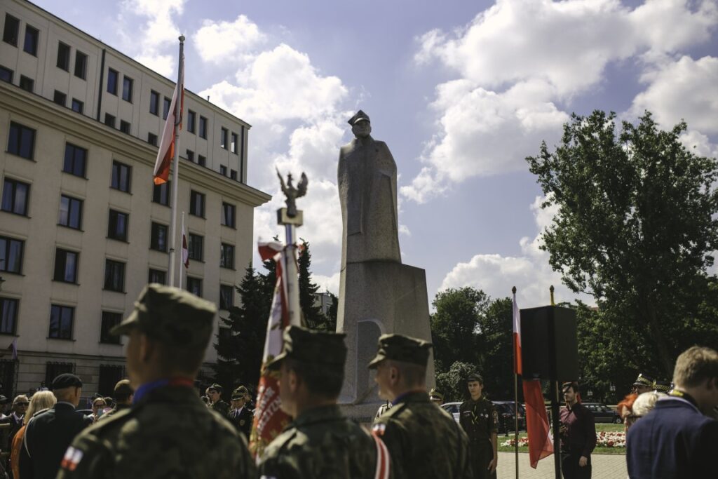 Uczestnicy uroczystości i poczty sztandarowe przed pomnikiem generała Stefana Roweckiego